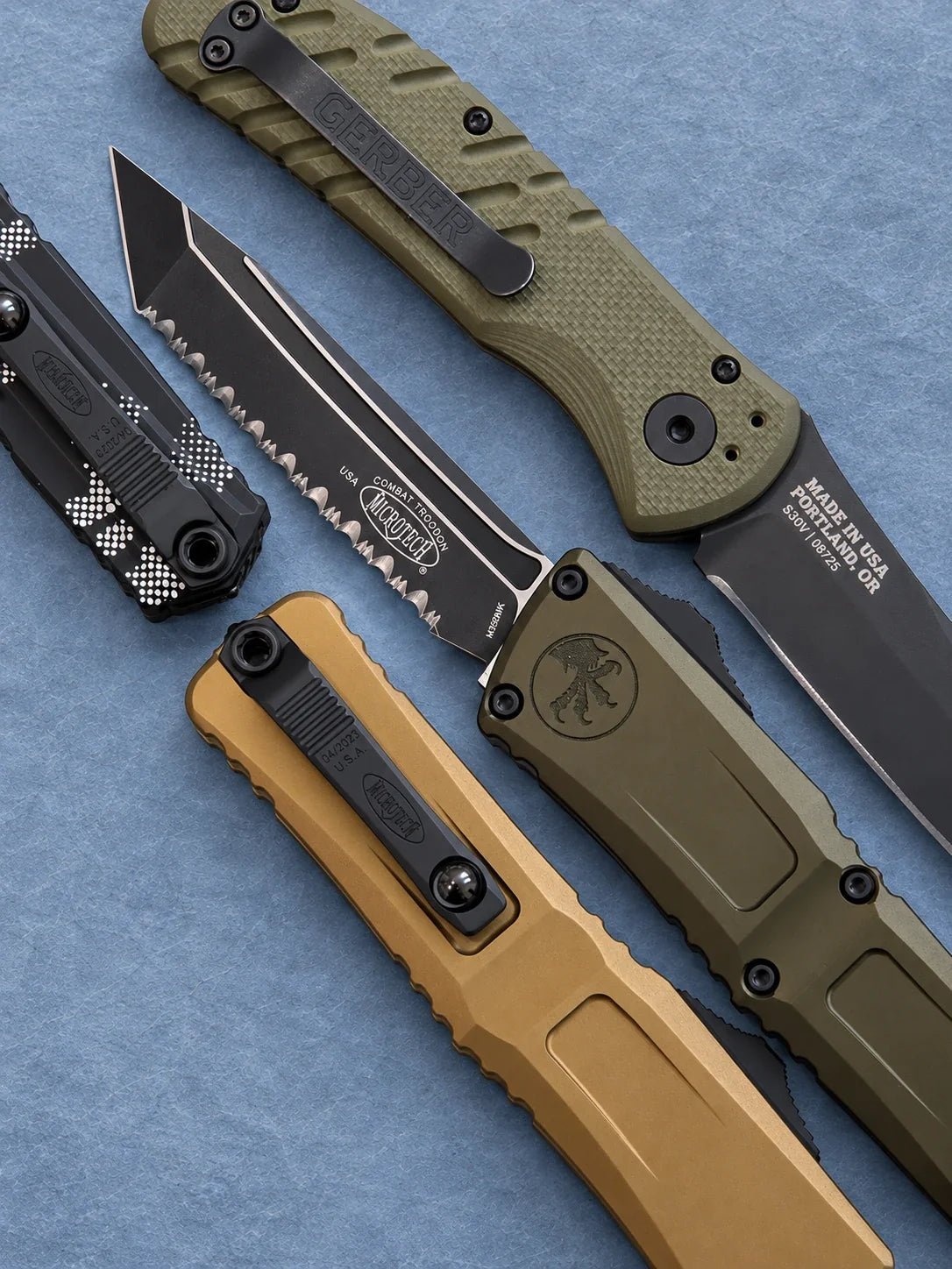 Premium automatic knives from Microtech and Gerber, featuring OTF and folding designs with tan, olive and camouflage handles.