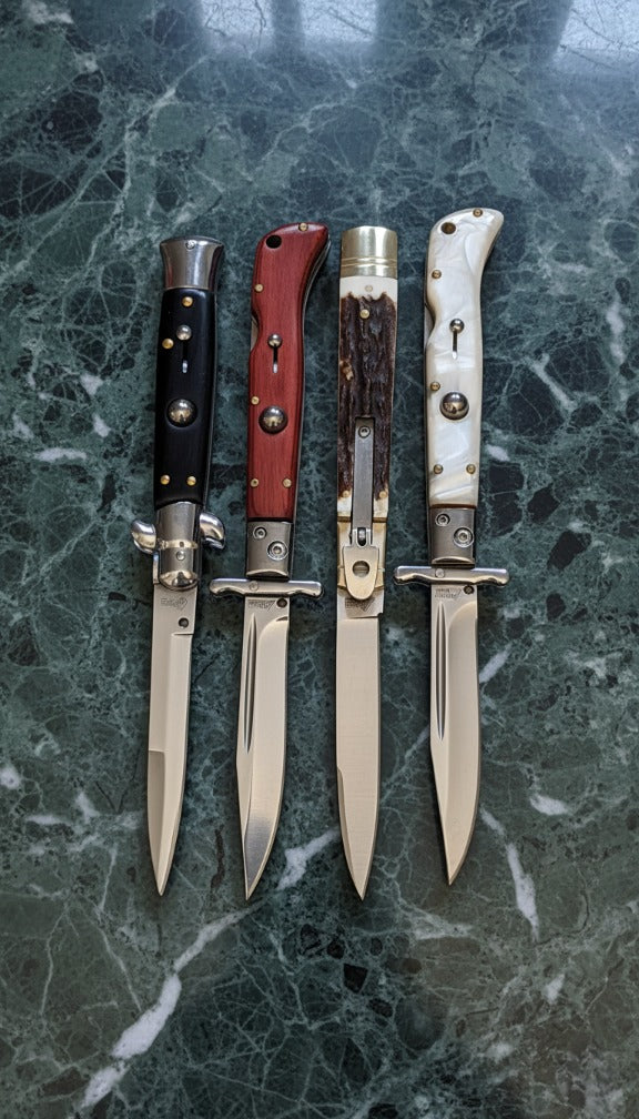 a Group of Switchblade Knives on a Granite Countertop