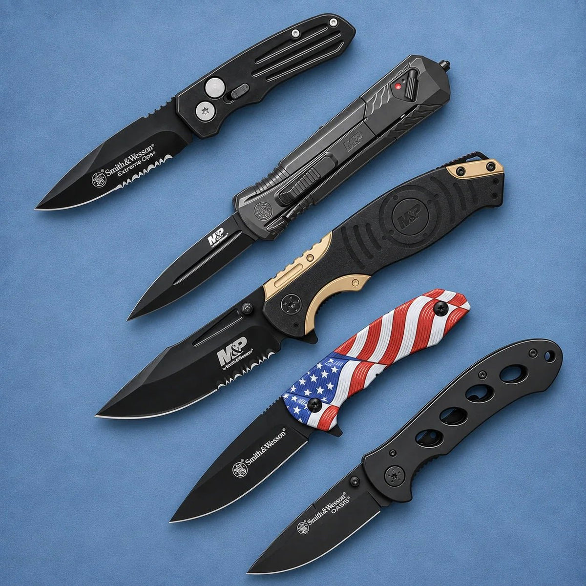 Five Smith & Wesson knives, including Extreme Ops, M&P folding and OTF models, an American flag handle knife, and OASIS, on a slate-blue background.