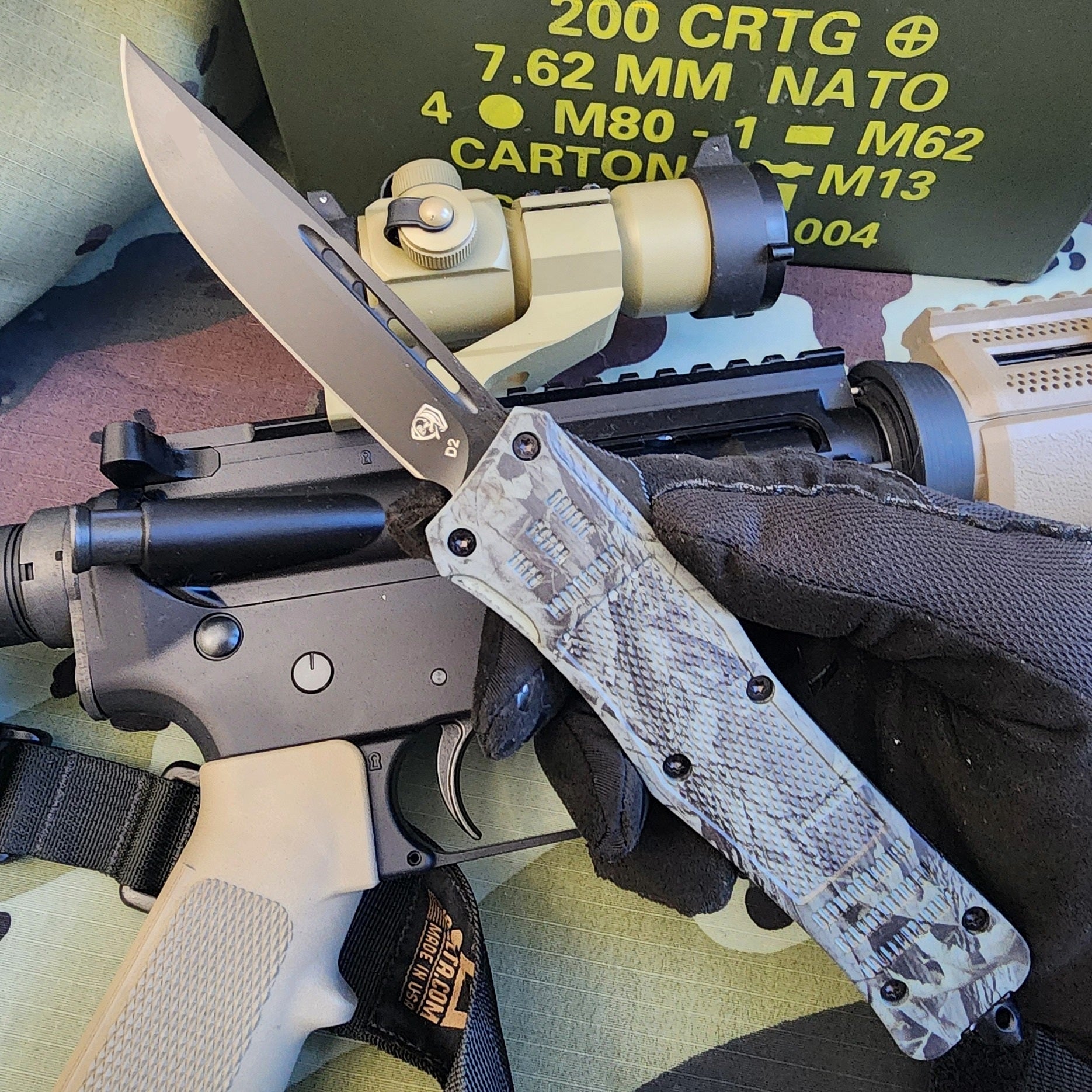 Folding knife with tactical rifle and camouflage background