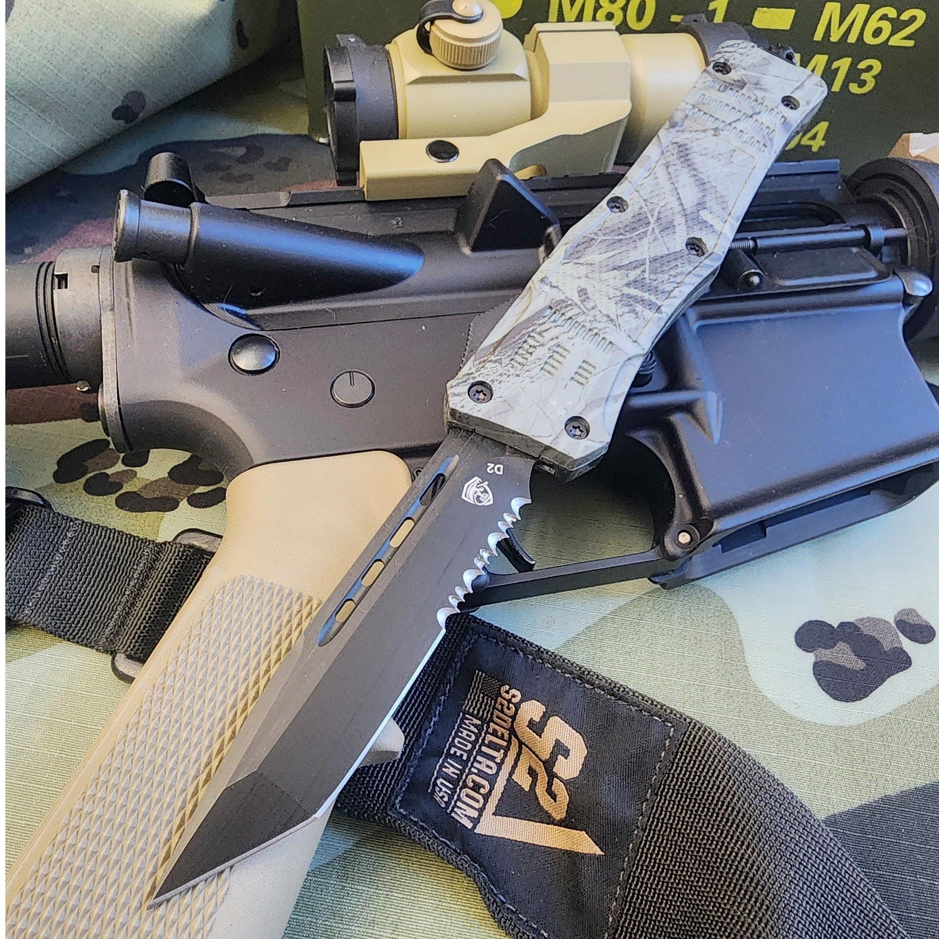 Automatic knife attached to a rifle with tactical equipment in the background