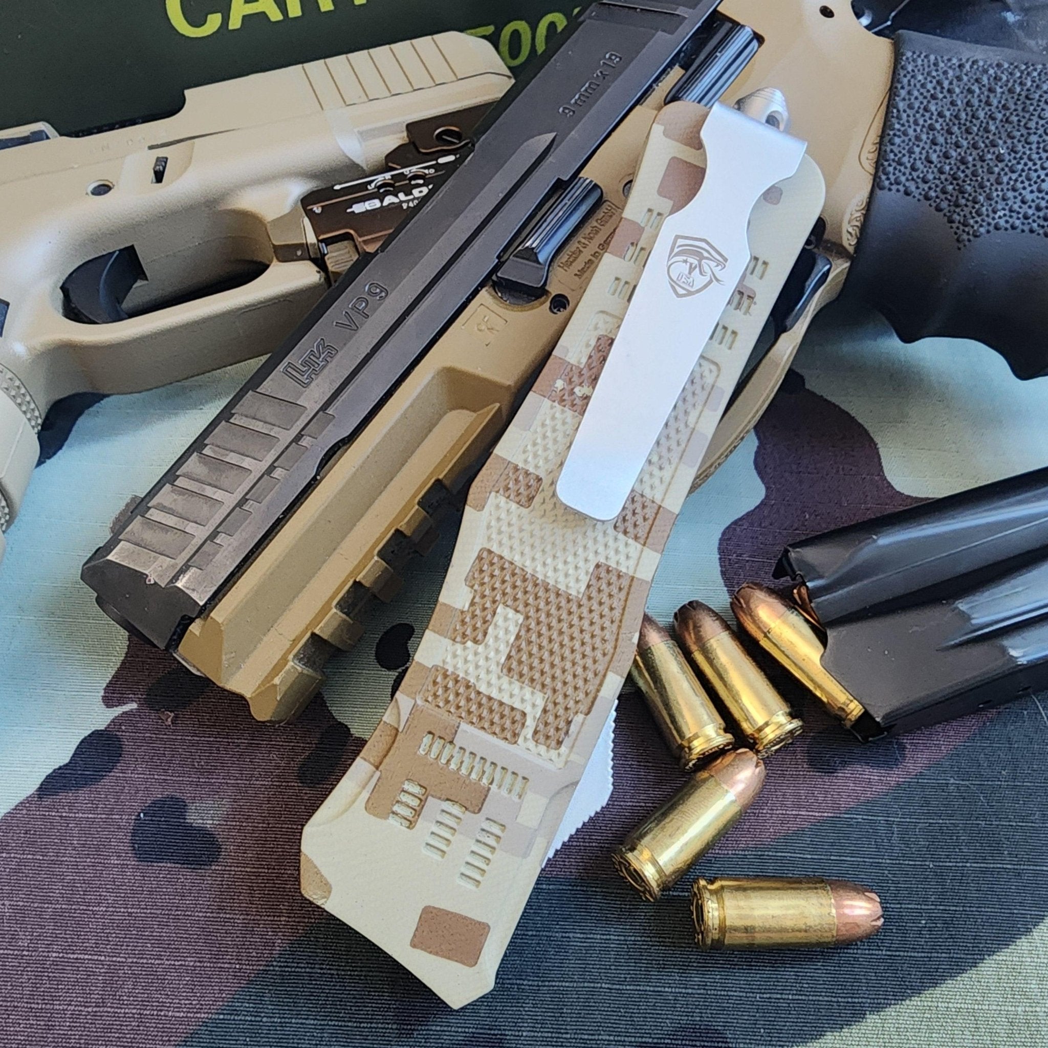 Camouflage knife with a gun and bullets on a camouflage-patterned surface