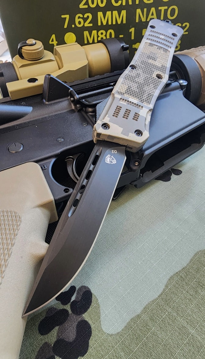 otf knife with tactical handle on a camouflage surface