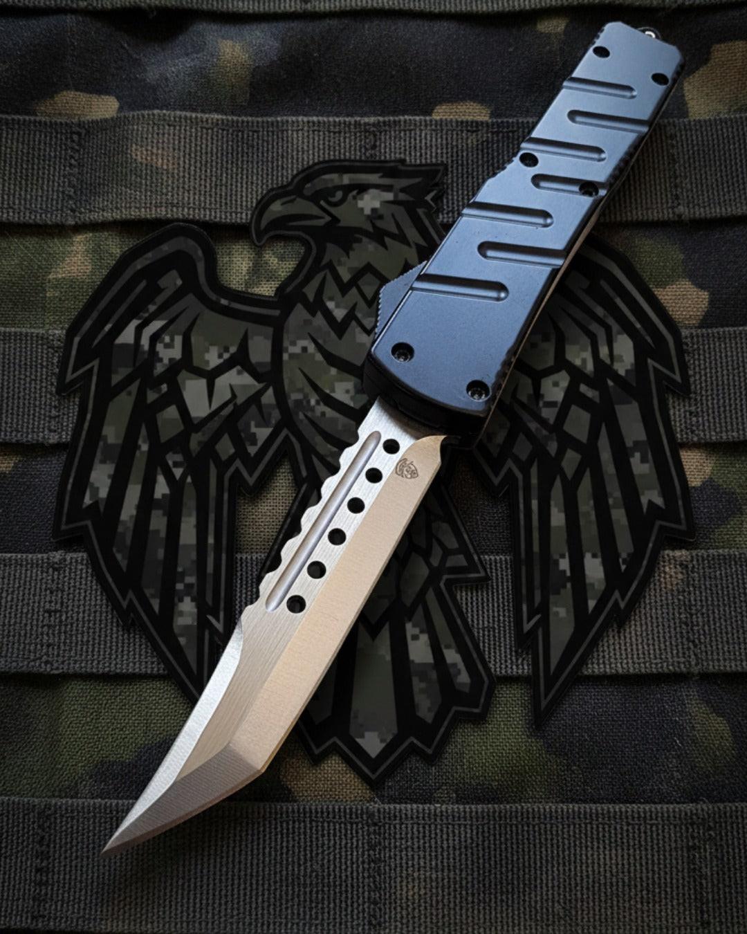 Automatic knife with a metallic blade and black handle on a camouflage background with an eagle emblem.