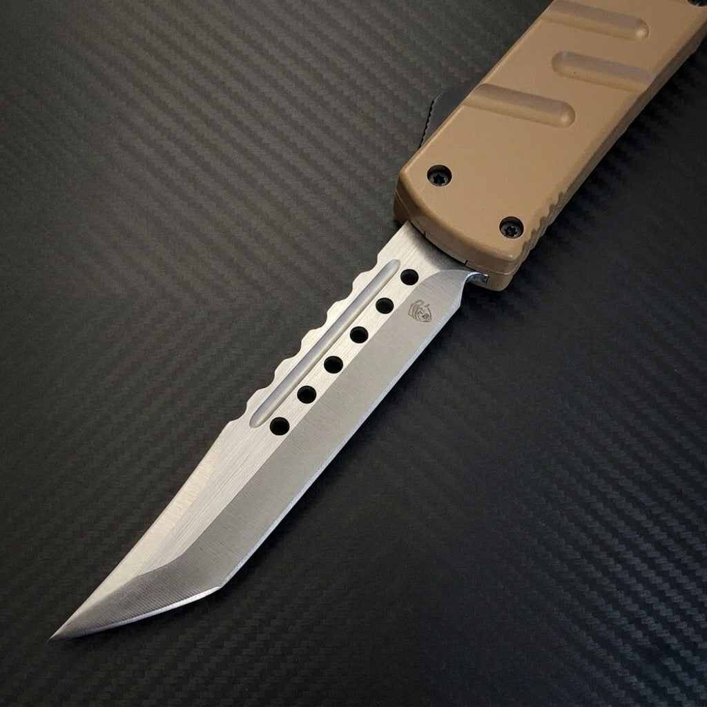 Automatic OTF knife with a tan handle on a textured black background
