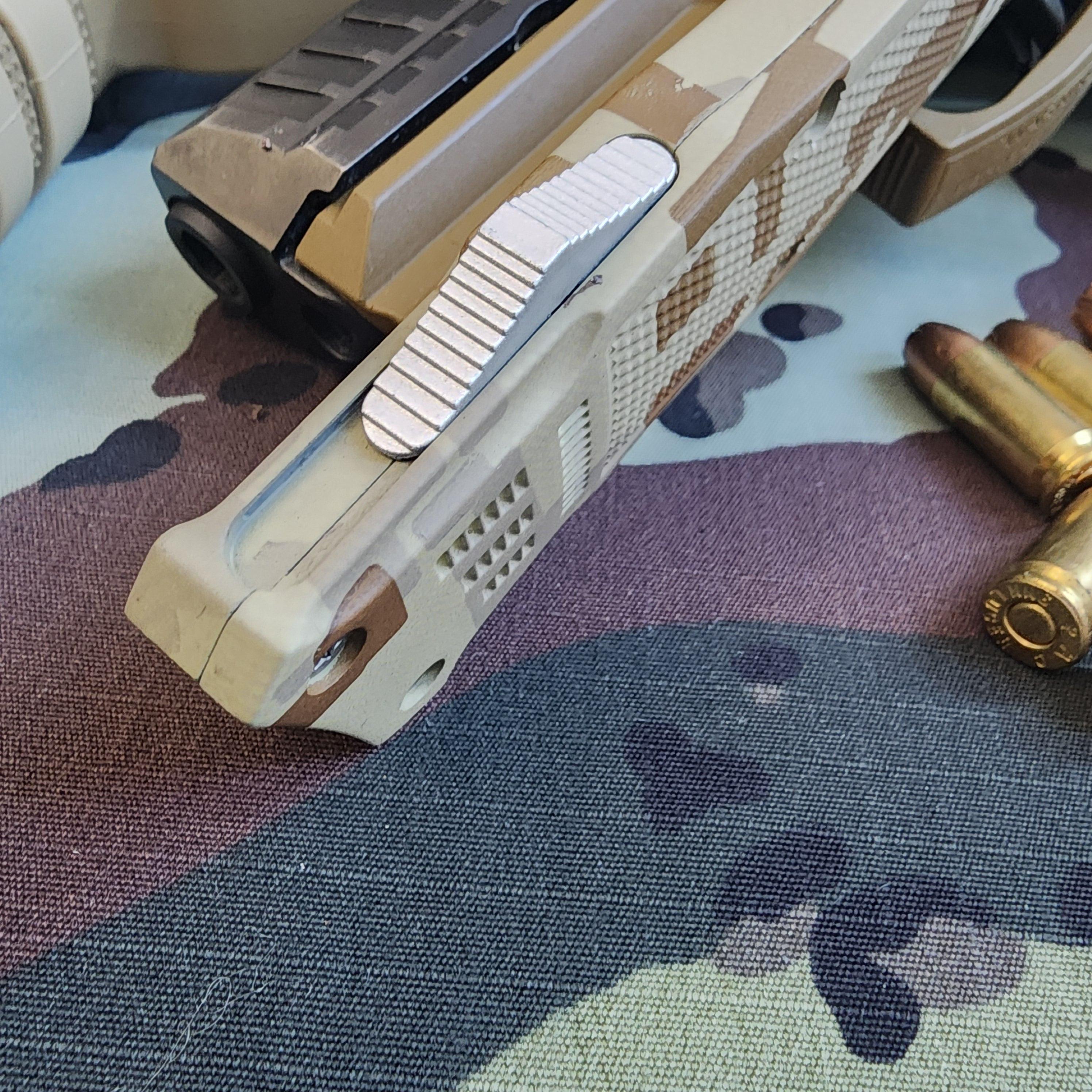 Close-up of a gun and ammunition on a camouflage surface