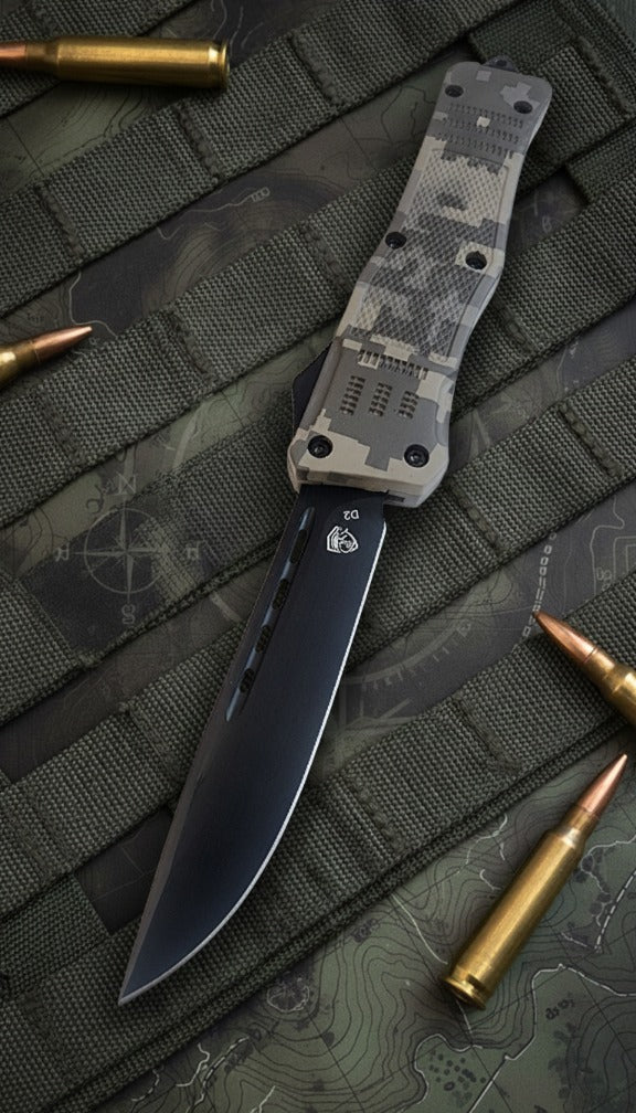 Knife with camouflage handle and blade on a textured surface with ammunition around