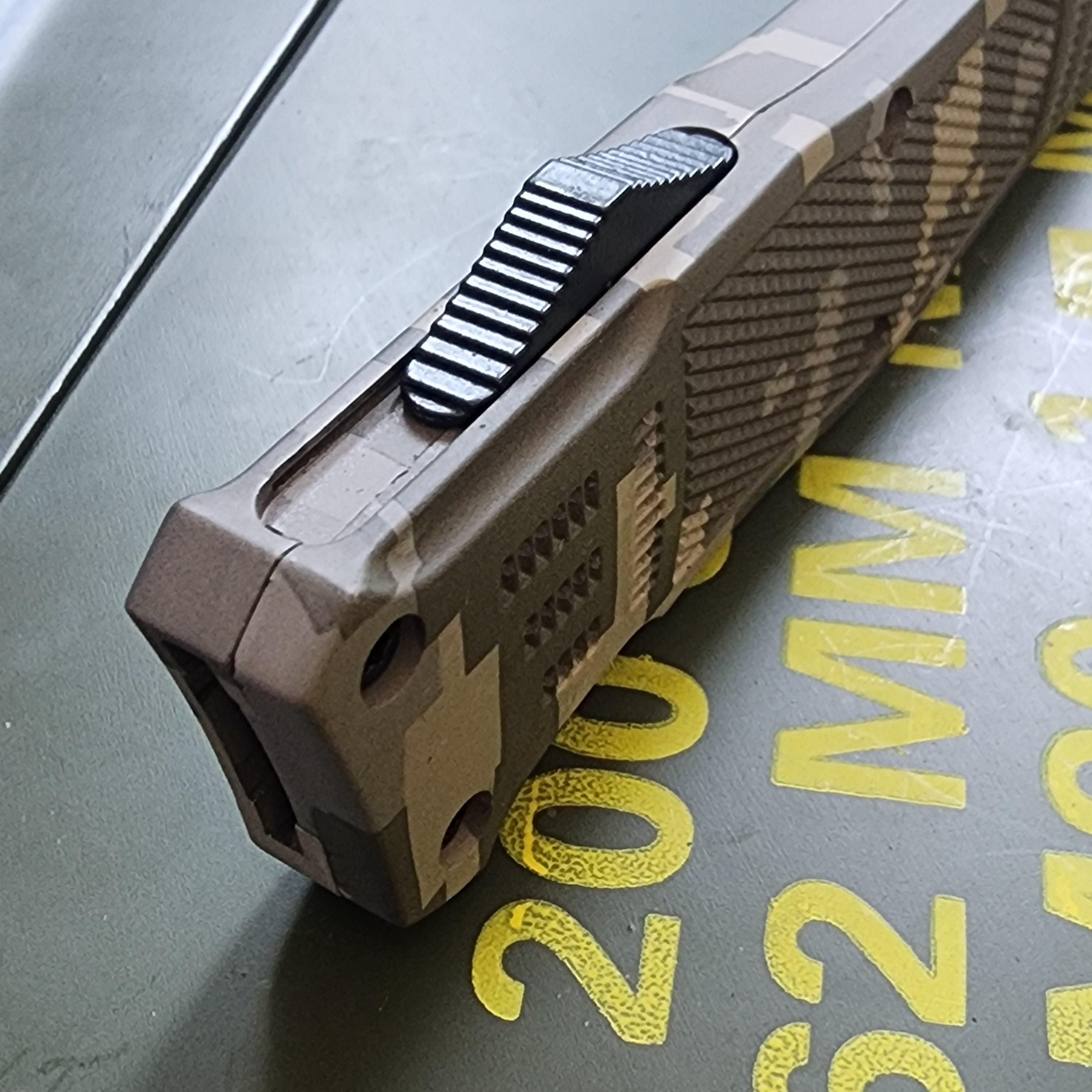 Close-up of a tactical knife with a textured handle on a metallic surface.