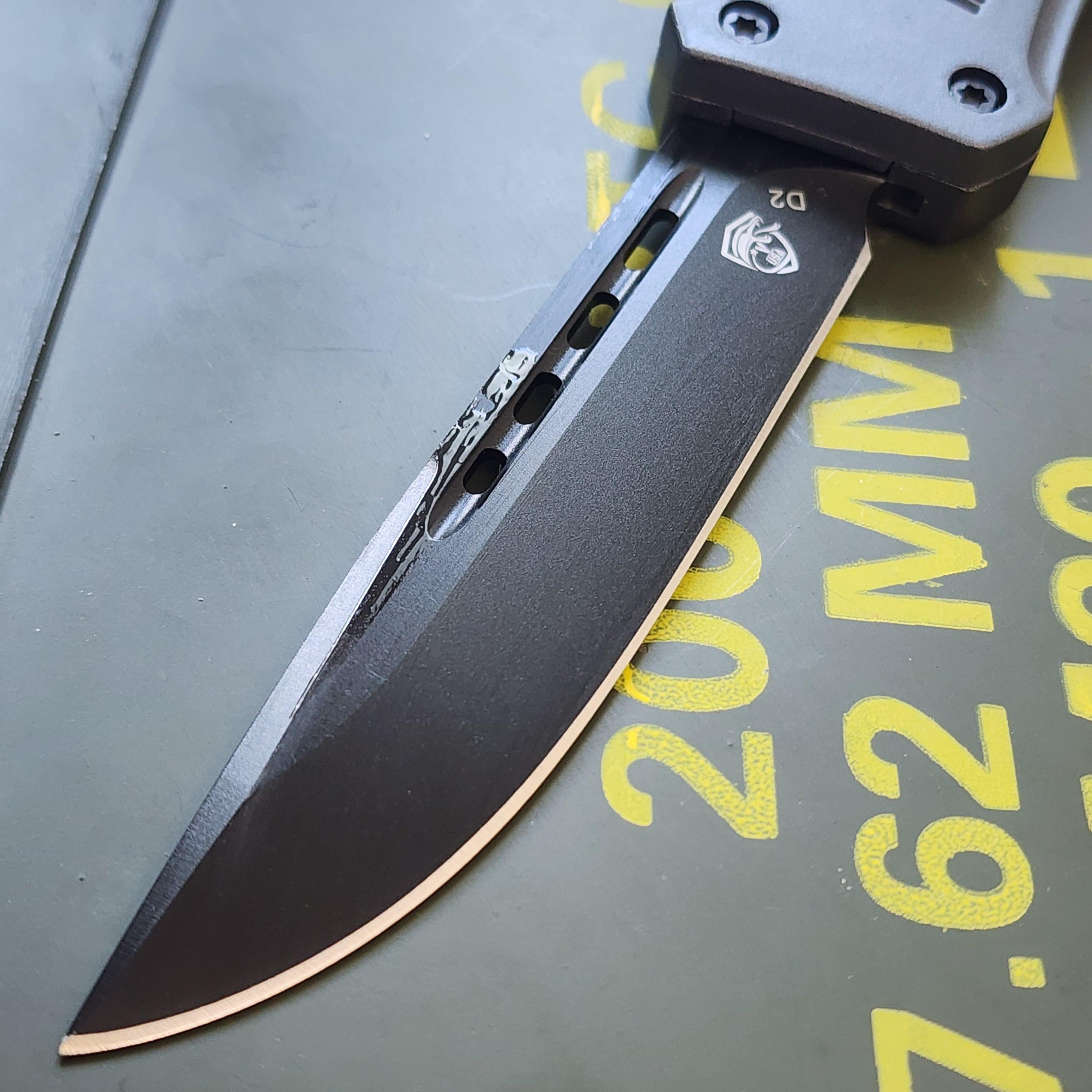 Folding knife with D2 blade logo on a gray surface with yellow text.