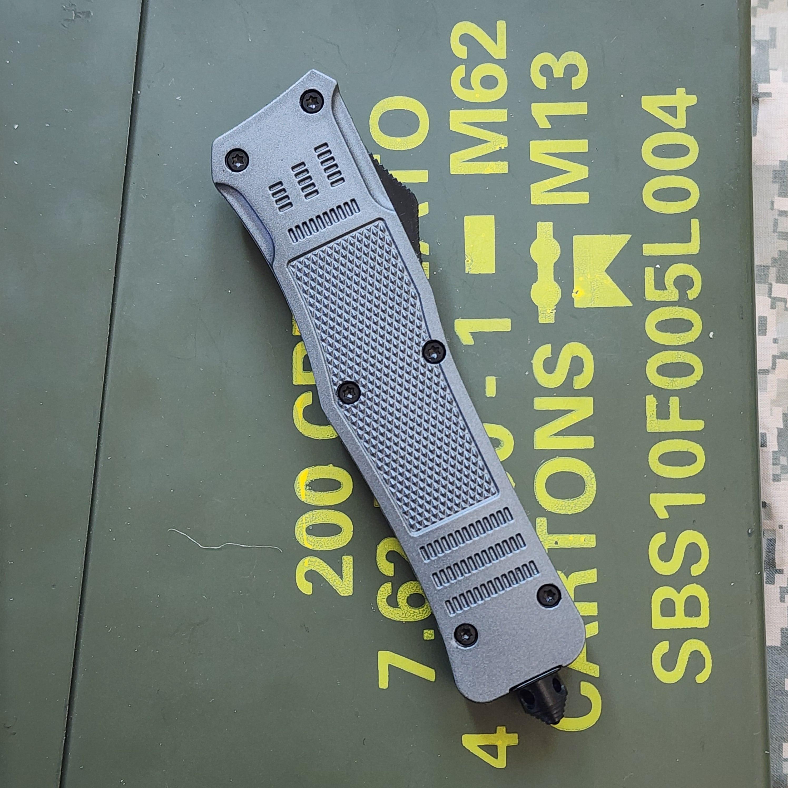 Folding knife on a green surface with text and logos in the background