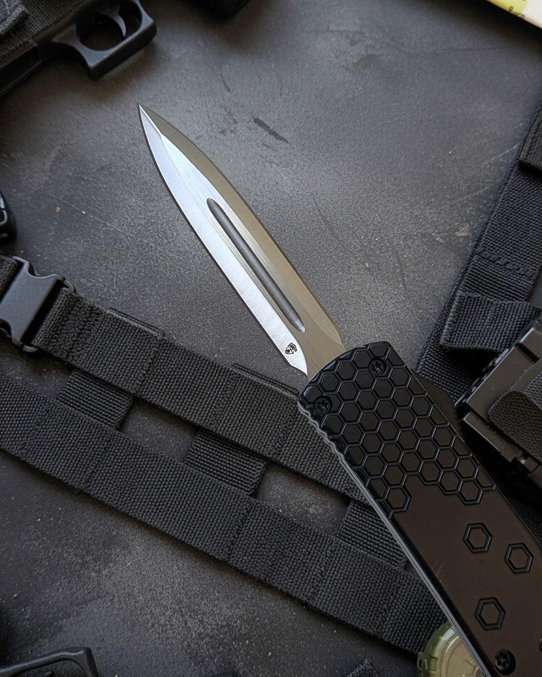 Tactical knife with black sheath on a textured surface