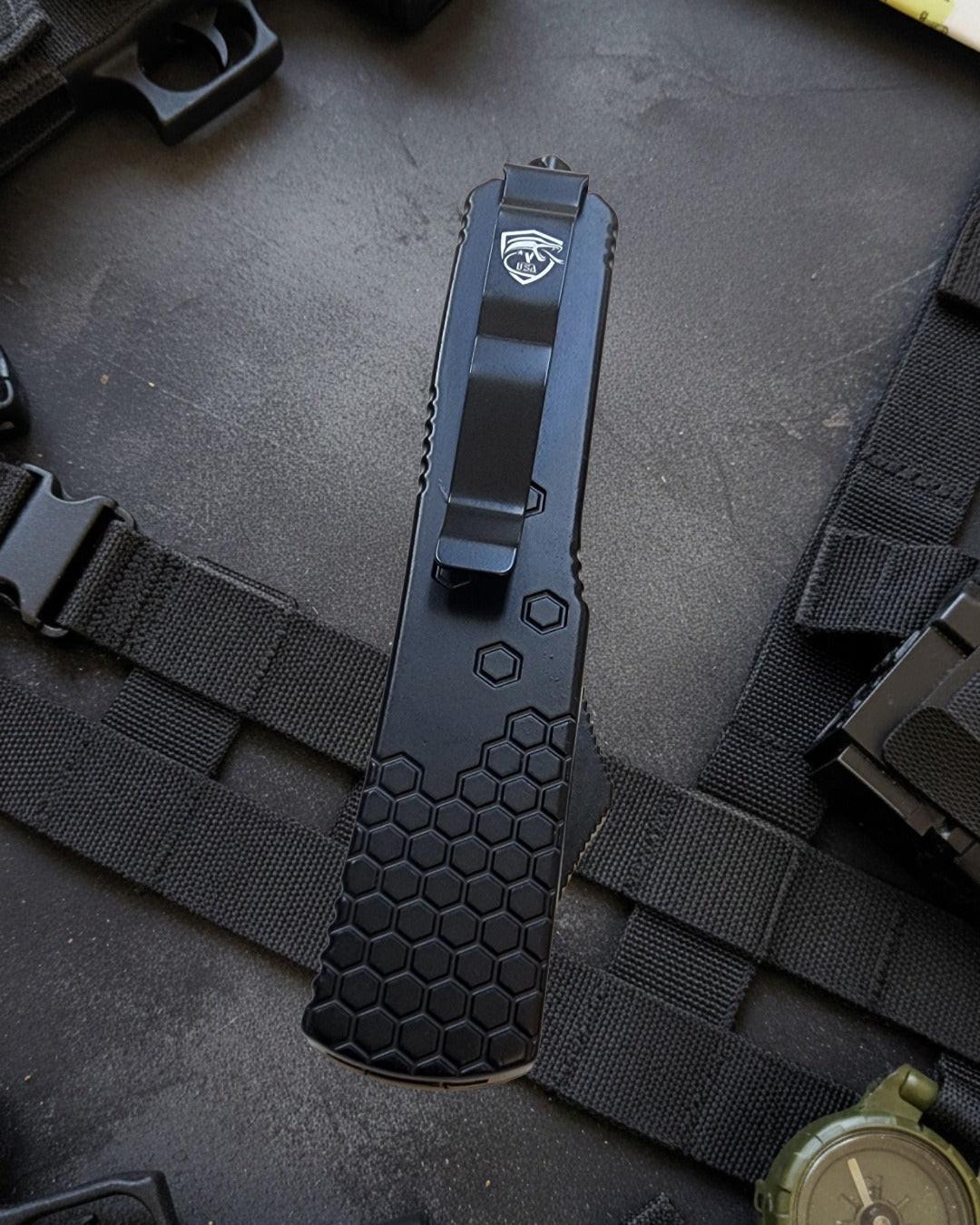 Black tactical knife with a hexagonal pattern on a dark background
