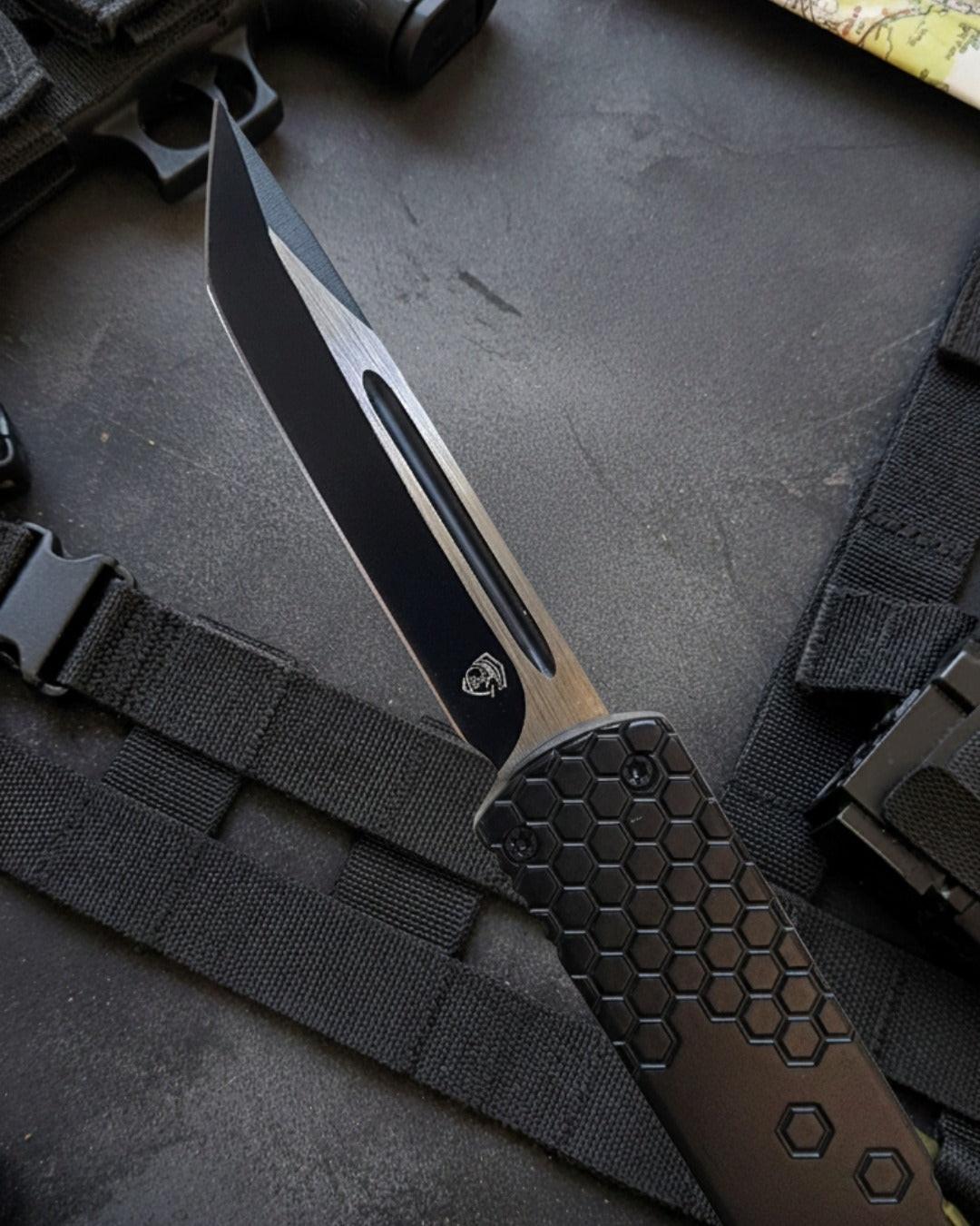 Tactical knife with a black handle on a dark surface